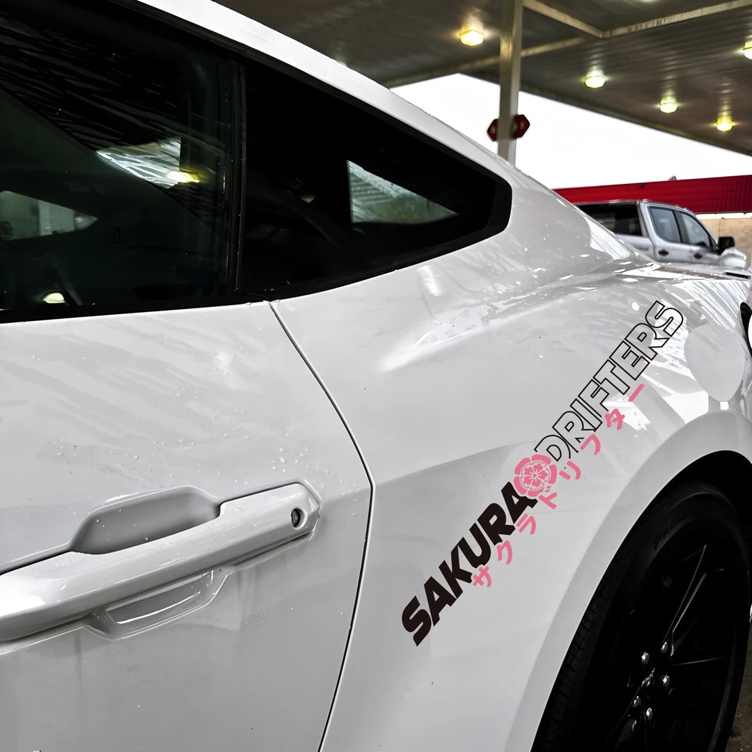 Sakura Drifters windshield sticker with pink cherry blossom design on a black modified car