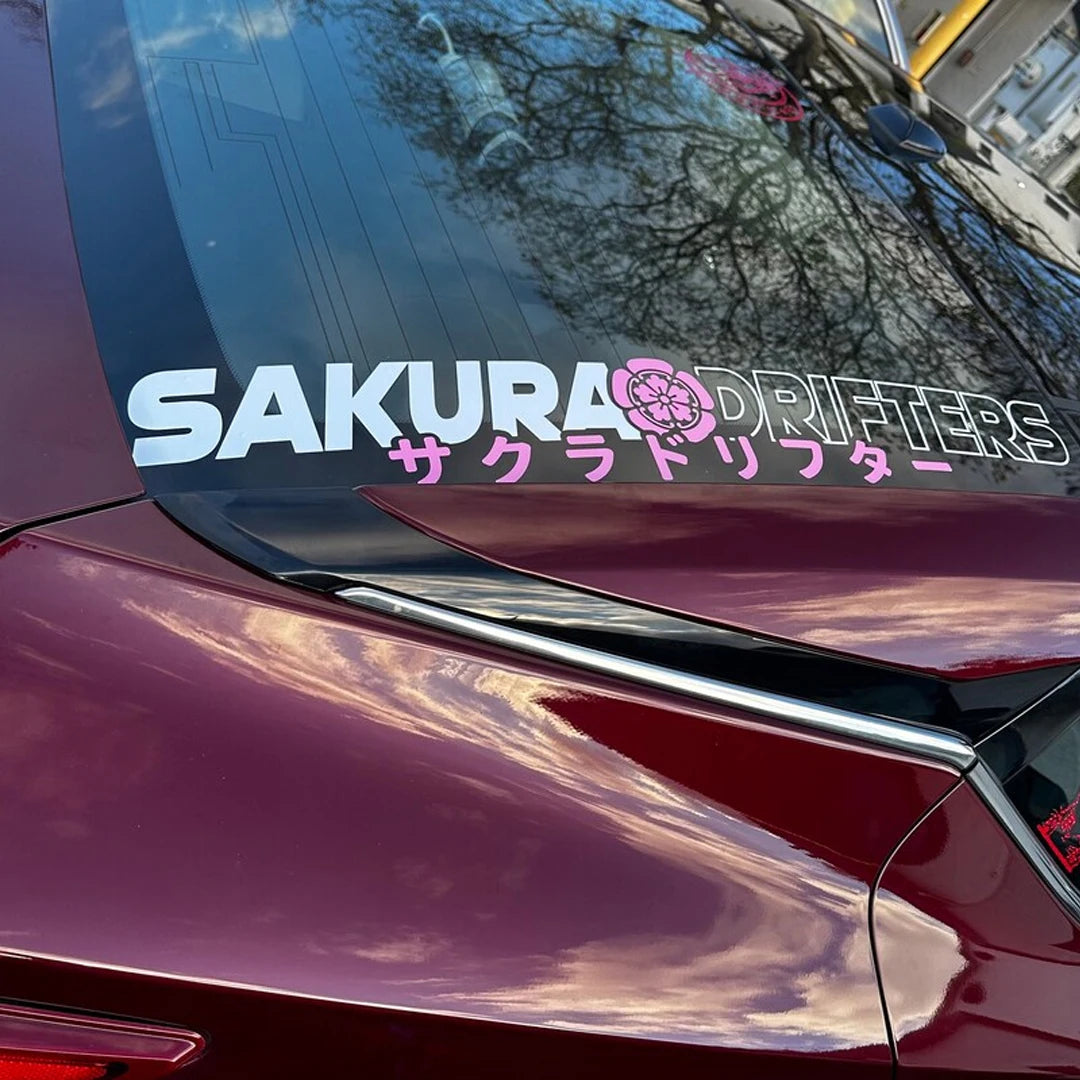 Sakura Drifters windshield sticker with pink cherry blossom design on a black modified car