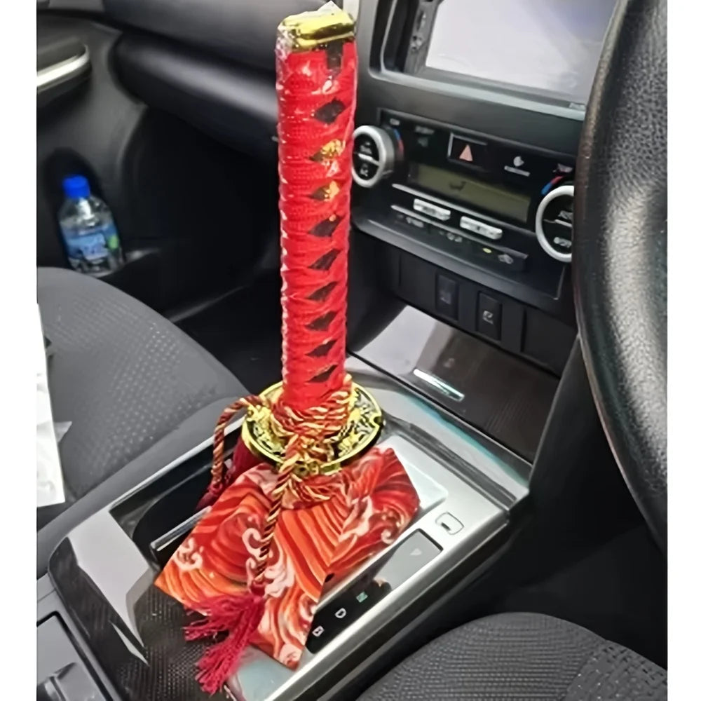 Samurai katana style manual shift knob with wrapped black and red grip installed in a car interior